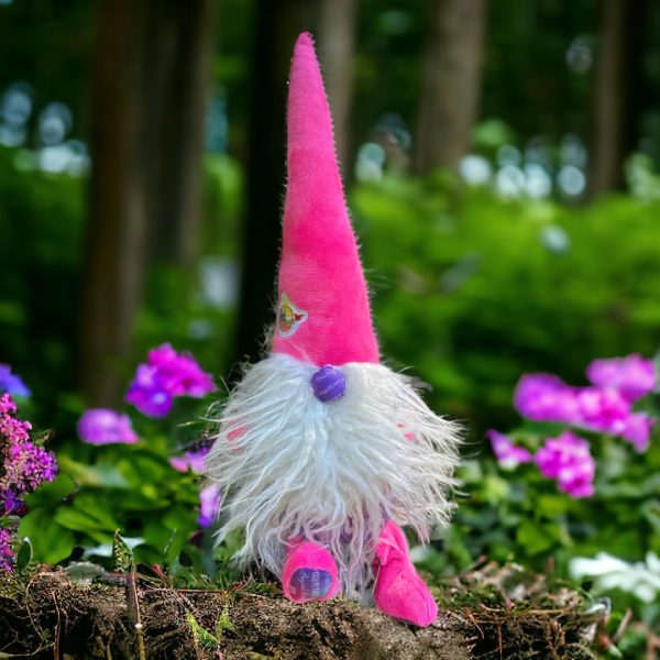 Pink gnome with long white beard sitting on stump in serene scene